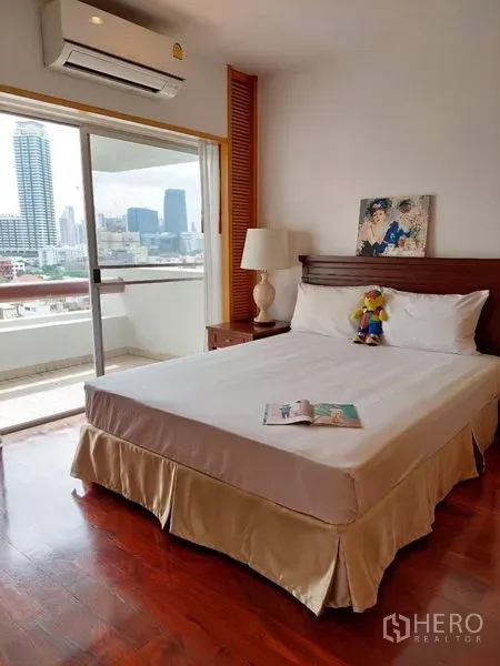 Apartment for rent - Bedroom opening to a balcony with city skyline views through sliding glass doors near MRT Lumphini.