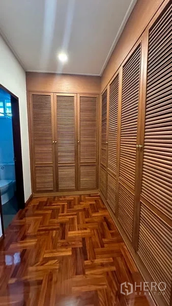 独立式住宅 出租在Watthana, Bangkok - 步入式衣帽间，木质百叶柜体。