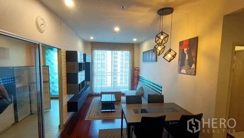 公寓 出售 - 明亮起居区，电视墙、餐桌与通向阳台的玻璃门