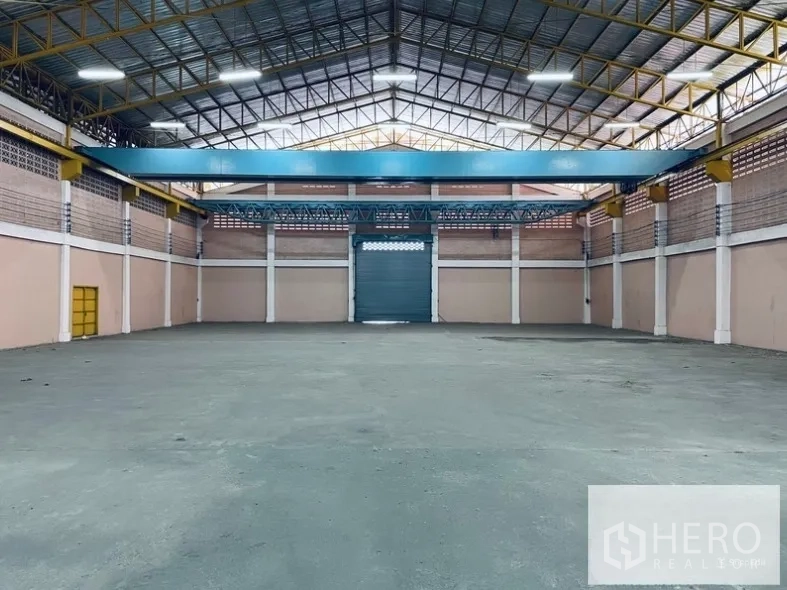 คลังสินค้า ให้เช่าในSam Phran, Nakhon Pathom - โถงภายในกว้าง มีคานเหล็กเหนือศีรษะสำหรับติดตั้งรอก และประตูม้วนกลางผนัง