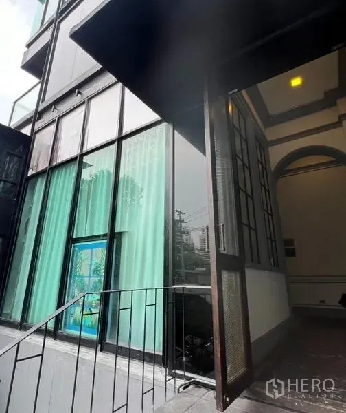 Retail Space for rent in Watthana, Bangkok - Exterior steps leading to a double-height shopfront with floor-to-ceiling windows and canopy.