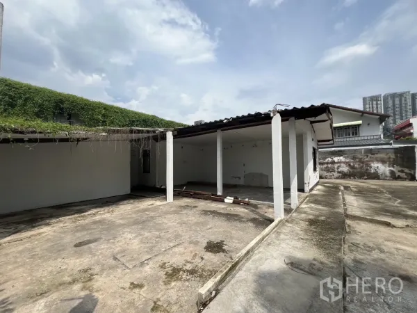 Detached House for rent in Phra Khanong, Bangkok - Side yard with open bays and large paved area beside a single-storey house.