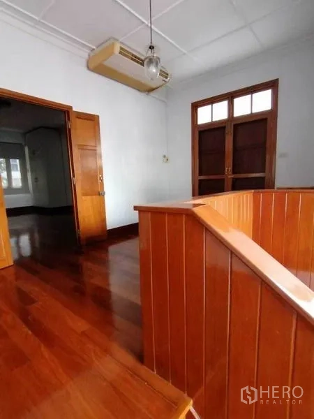 独立式住宅 出租在Pathum Wan, Bangkok - 二层平台，木质栏杆、双扇木门和壁挂空调与灯具