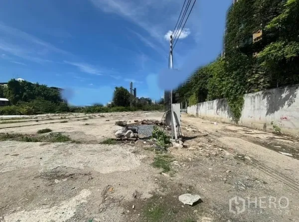 Land for rent in Khlong Toei, Bangkok - Cleared land plot with concrete base, power pole and walled boundary under blue sky in Ekkamai.