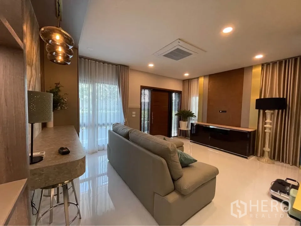 独栋房屋 for rent or sale in Bang Phli, Samut Prakan - 客厅明亮，配大沙发、电视柜与筒灯照明。