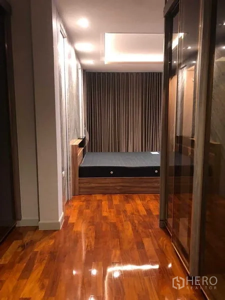 Detached House for rent in Bang Khae, Bangkok - Hallway lined with mirrored wardrobes leading to a bedroom with wooden floors.