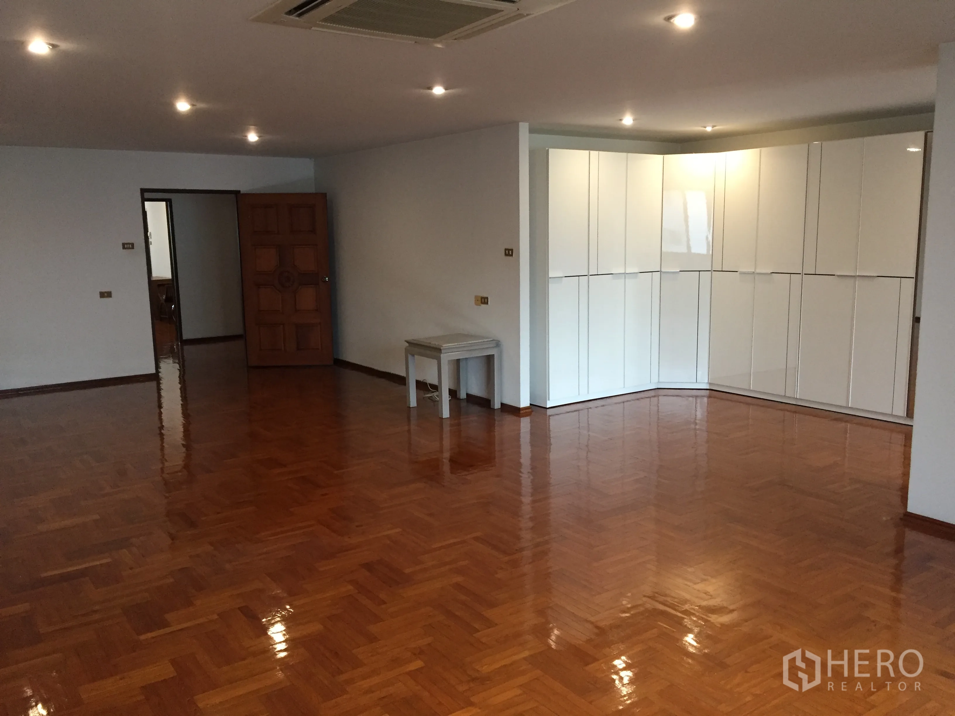 公寓 出租在Watthana, Bangkok - 开放式客厅，实木拼花地板、筒灯和转角内置柜