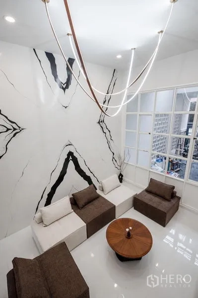 Townhouse for sale - Aerial view of the double-height living space with artistic wall and chandelier.