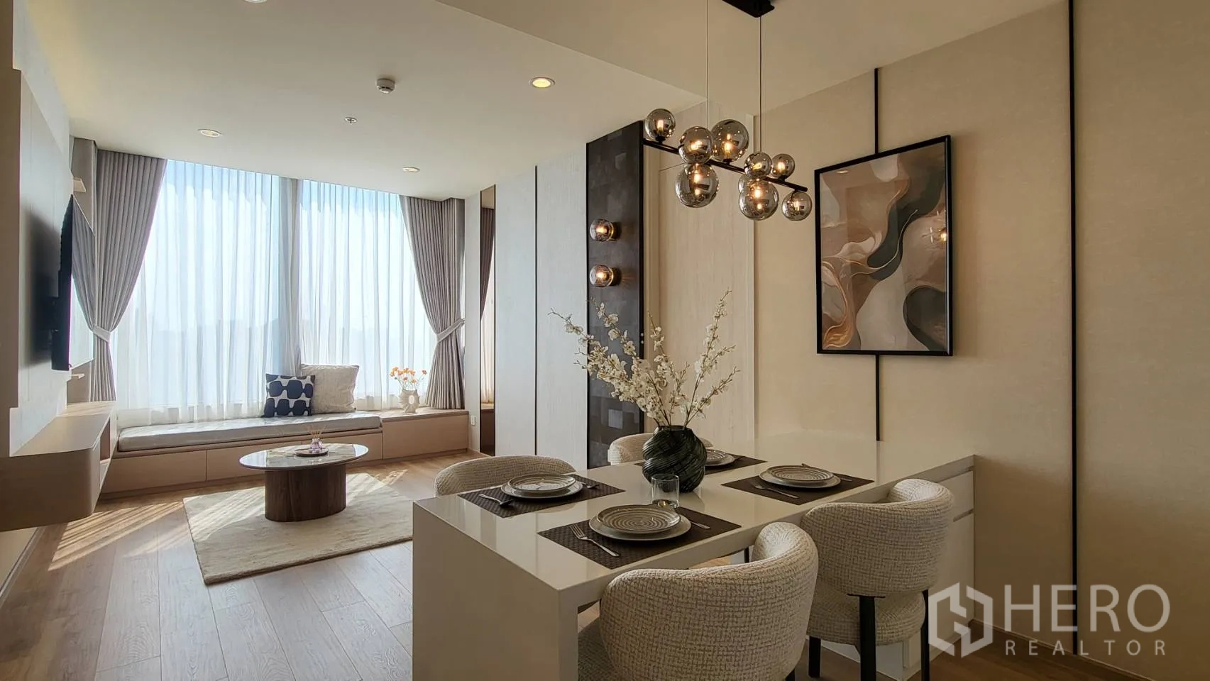 คอนโด for sale in Watthana, Bangkok - โซนนั่งเล่นมีม้านั่งข้างหน้าต่าง โต๊ะกาแฟกลม โคมไฟโมเดิร์น และโทนตกแต่งสบายตา