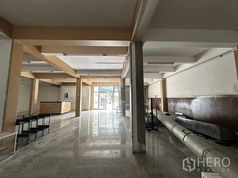 Retail Space for rent in Bang Rak, Bangkok - Large retail hall facing a glass entrance with natural light and a small movable counter.