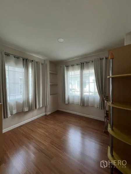 Detached House for rent in Bang Kapi, Bangkok - Another view of the corner room with wraparound windows and wood floors.