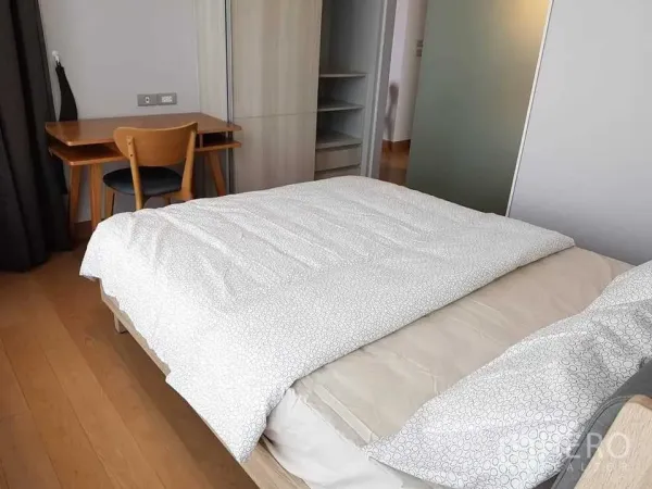 Condominium for rent in Khlong Toei, Bangkok - Cozy bedroom with double bed, built-in wardrobe and a small work desk by the window.