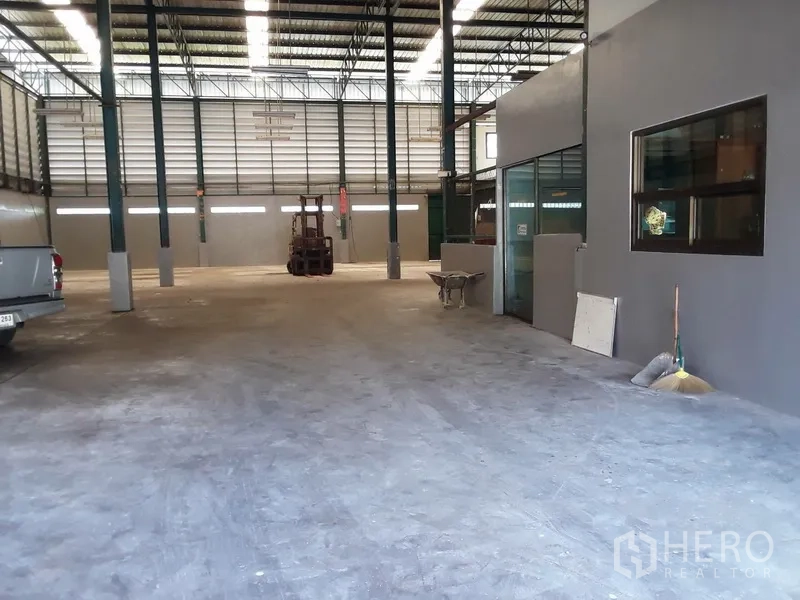 工厂 出租在Saphan Sung, Bangkok - 宽阔过道，内置玻璃办公室、皮卡车与开放作业区。