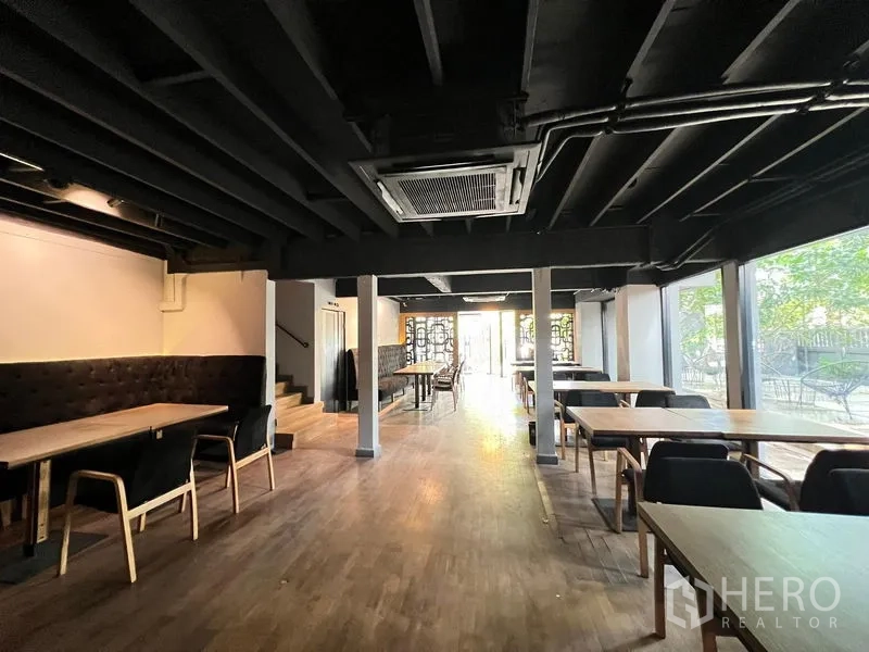 Retail Space for rent in Bangkok - Dining space with exposed black ceiling, timber floor and full-height windows to the garden.