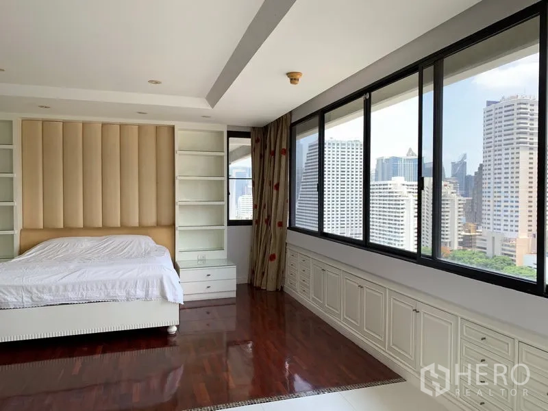 Condominium for sale in Khlong Toei, Bangkok - Master bedroom angle showing full-length windows and skyline outlook.