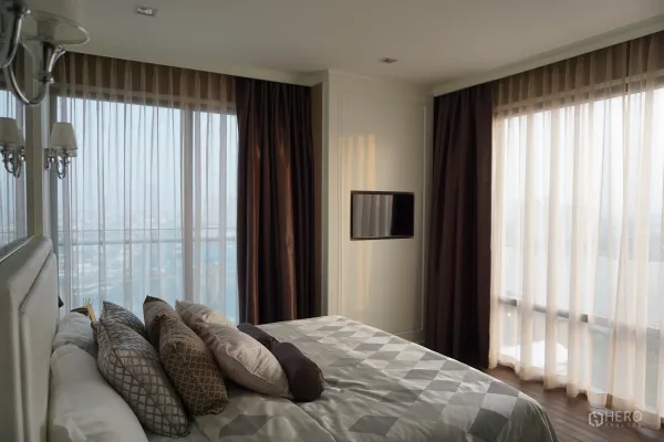 Condominium for rent in Bang Kho Laem, Bangkok - Primary bedroom with floor-to-ceiling windows, sheer drapes, built-in TV and city–river view.