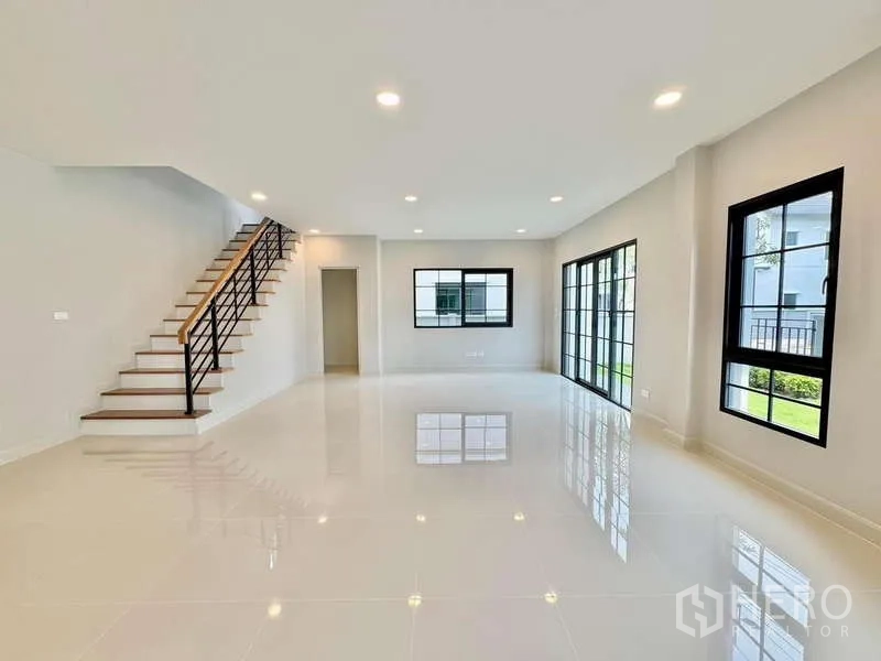 独立式住宅 出售在Bang Phli, Samut Prakan - 客厅视角可见楼梯与通往花园的推拉门