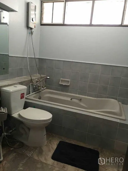 Townhouse for rent or sale in Suan Luang, Bangkok - Bathroom with bathtub, toilet and window lighting.