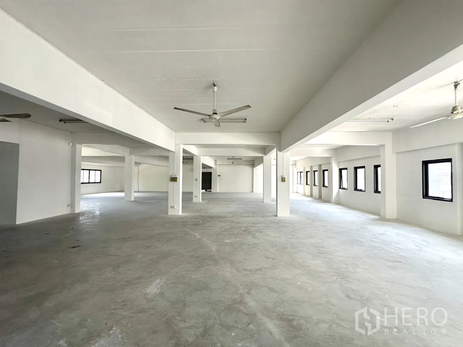 Warehouse for rent in Bang Phli, Samut Prakan - Long floor plate with rows of windows and ceiling fans for ventilation.