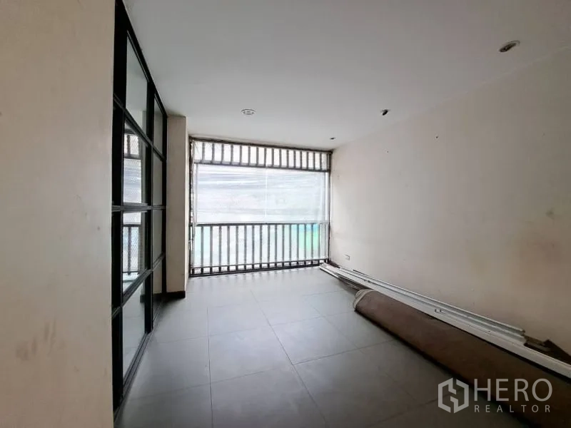 Shophouse for rent in Watthana, Bangkok - Bright room with tiled floor and screened front balcony.