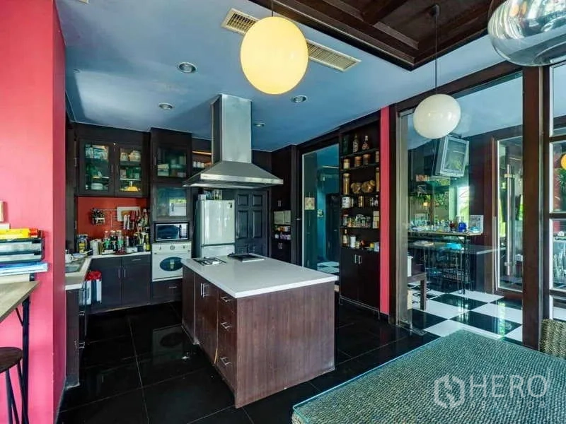 独立式住宅 出售在Suan Luang, Bangkok - 开放式厨房，带中岛、抽油烟机和深色橱柜。