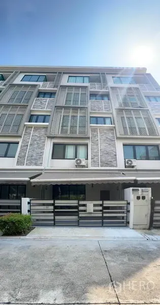 Townhouse for rent or sale in Yan Nawa, Bangkok - Contemporary multi-storey townhouse facade with louvered panels and a gated carport under bright sunlight.