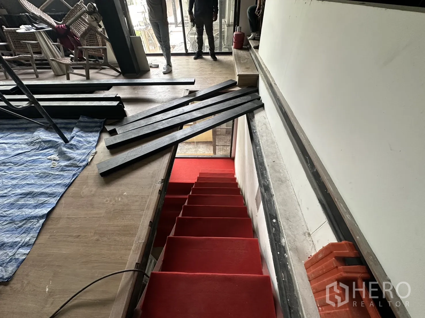 พื้นที่ขายของ for rent in Watthana, Bangkok - มุมมองจากชั้นบนลงสู่บันไดพรมแดงและประตูกระจกชั้นล่าง.