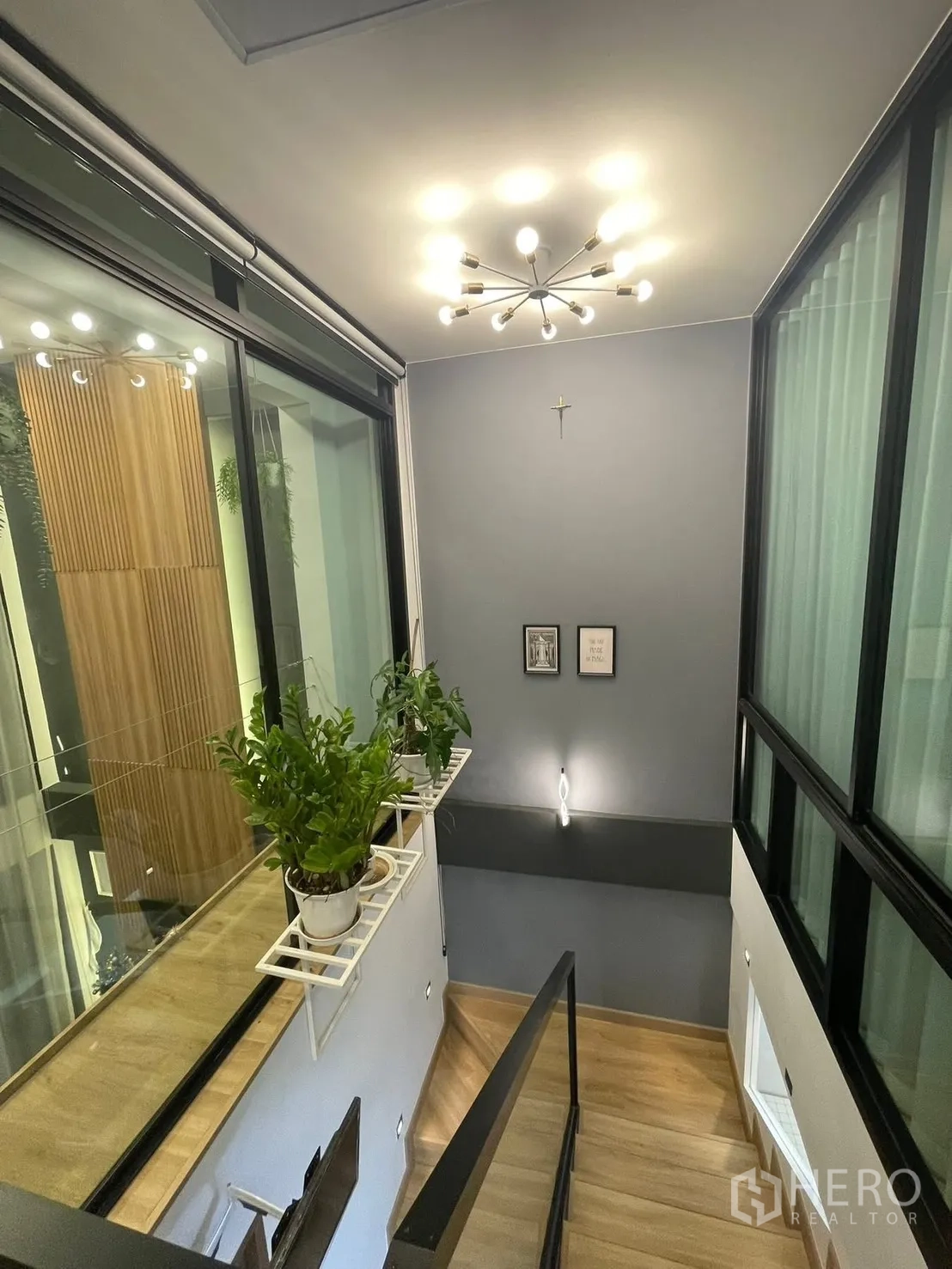 Home Office for rent or sale in Bang Kapi, Bangkok - Stairwell with glass balustrade, indoor plants and a modern chandelier.