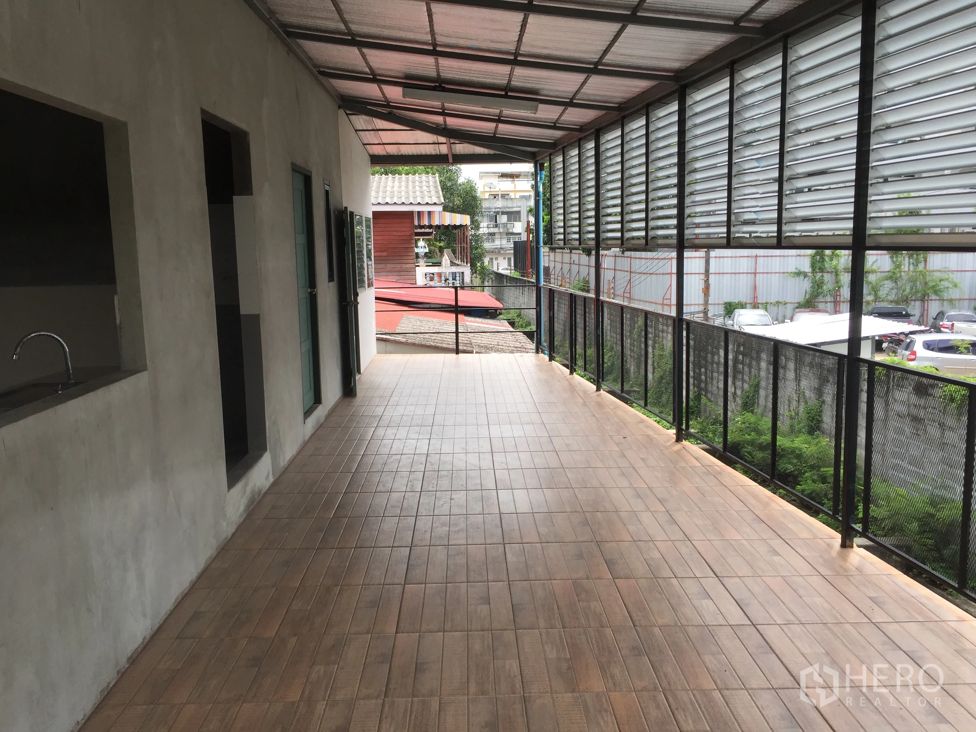 独立式住宅 出租在Din Daeng, Bangkok - 加盖长阳台，仿木地砖与百叶遮挡，俯瞰社区景观。