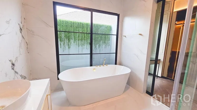 บ้าน ให้เช่าหรือขายในSaphan Sung, Bangkok - ห้องน้ำหรู อ่างอาบน้ำแบบลอยตัวข้างหน้าต่าง มองเห็นสวนสีเขียว