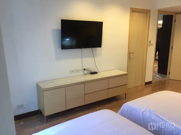 公寓 出租在Pathum Wan, Bangkok - 次卧设双床、壁挂电视及浅木色收纳柜