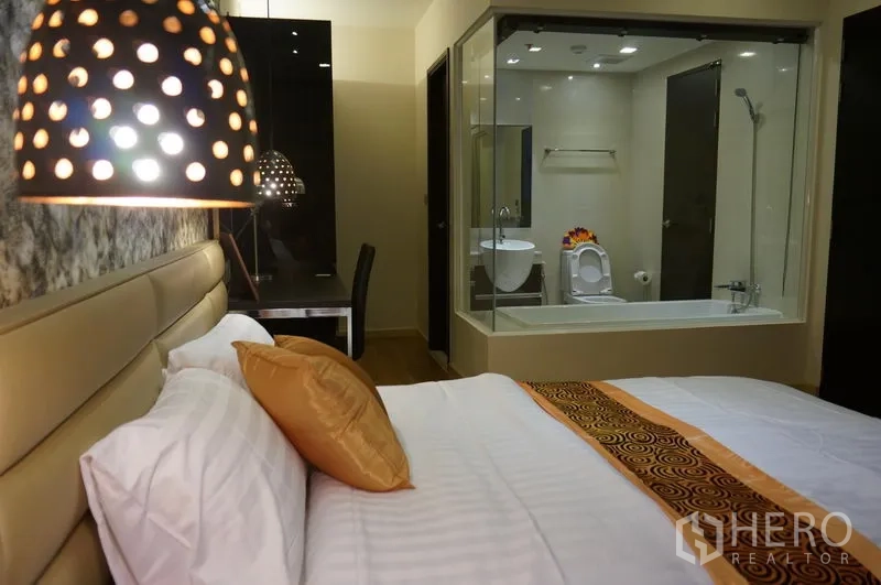 公寓 出租在Watthana, Bangkok - 带玻璃隔断的套内卫浴，配浴缸、淋浴与现代洁具，可从卧室看到。