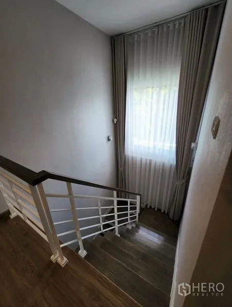 独立式住宅 出租在Prawet, Bangkok - 木质楼梯与大窗帘窗户，采光充足。