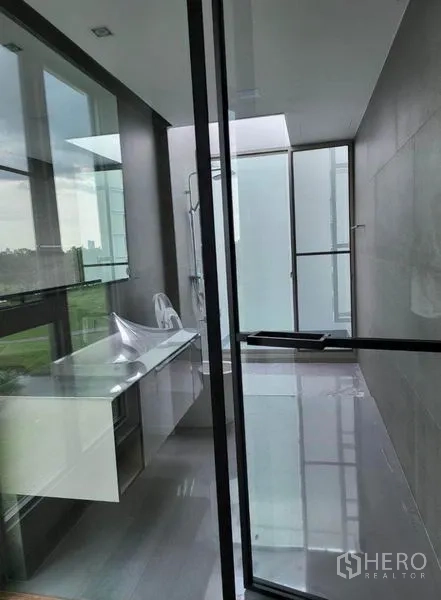 独立式住宅 出租在Saphan Sung, Bangkok - 现代卫浴，落地窗、玻璃隔断与长台面，自然采光充足。