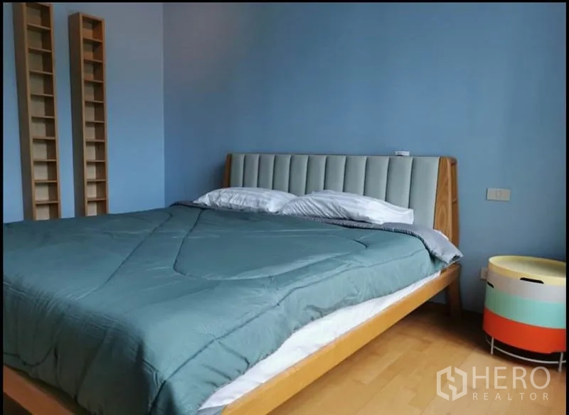 Condominium for rent in Khlong Toei, Bangkok - Close view of the bedroom showing upholstered headboard and wooden bed frame.