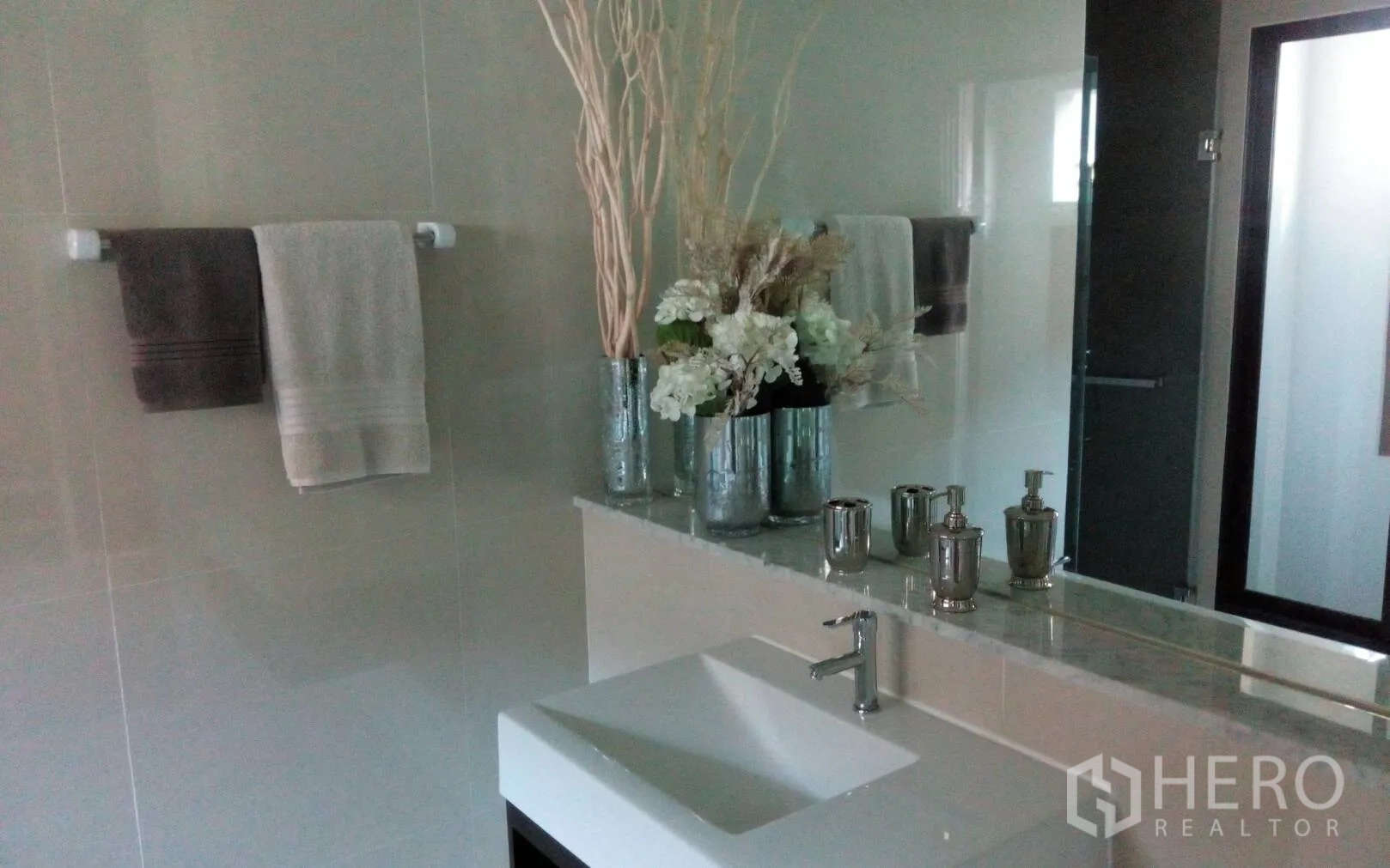 Detached House for rent or sale in Prawet, Bangkok - Contemporary bathroom with single vanity, large mirror and chrome fittings.