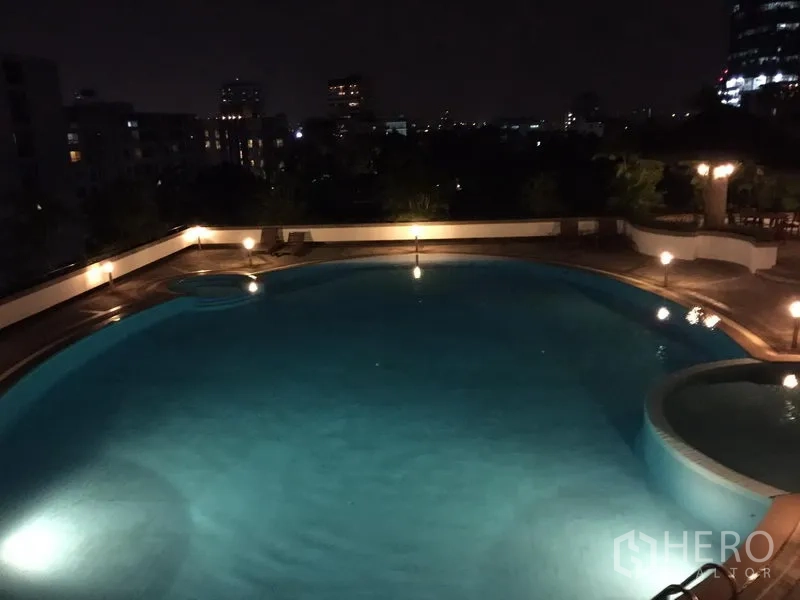 公寓 出售在Watthana, Bangkok - 夜间室外泳池，远眺城市天际线