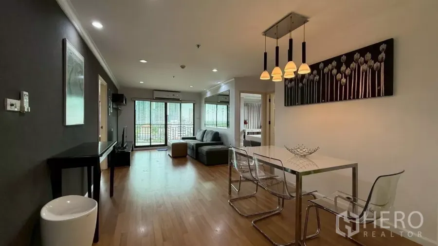 公寓 出售在Yan Nawa, Bangkok - 开放式客餐厅，木地板、吊灯以及通往阳台的推拉门。