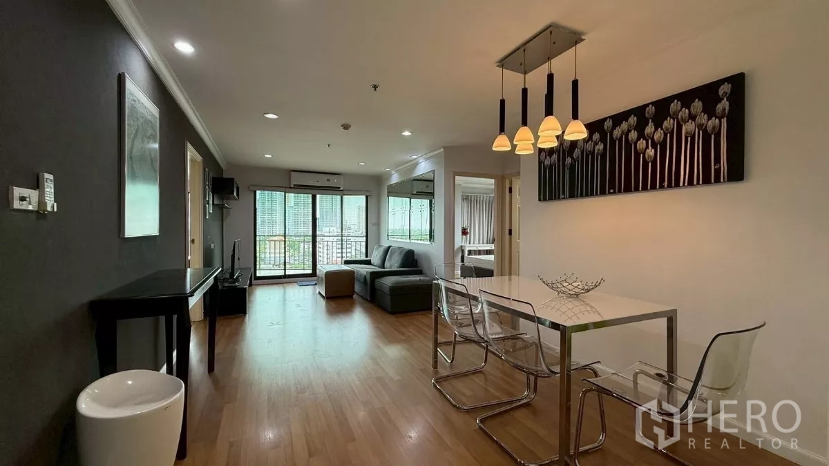 公寓 出售在Yan Nawa, Bangkok - 开放式客餐厅，木地板、吊灯以及通往阳台的推拉门。