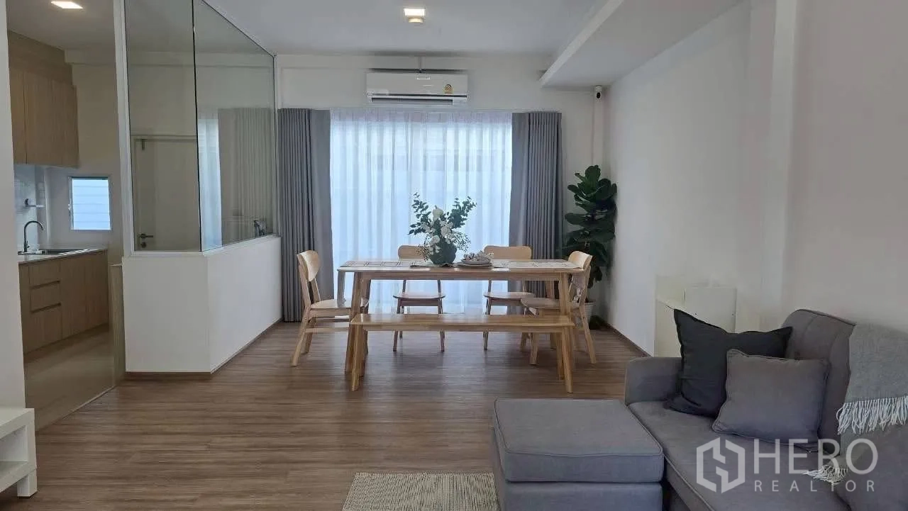 ทาวน์เฮาส์ for rent in Prawet, Bangkok - พื้นที่นั่งเล่นเชื่อมต่อห้องทานอาหาร ครัวกั้นกระจก และผ้าม่านสูงจรดเพดาน