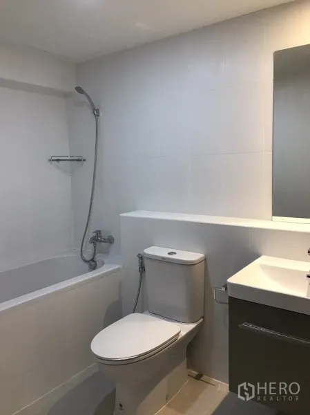 公寓 出租在Watthana, Bangkok - 现代浴室，浴缸带手持花洒，坐便器及简洁台盆柜。