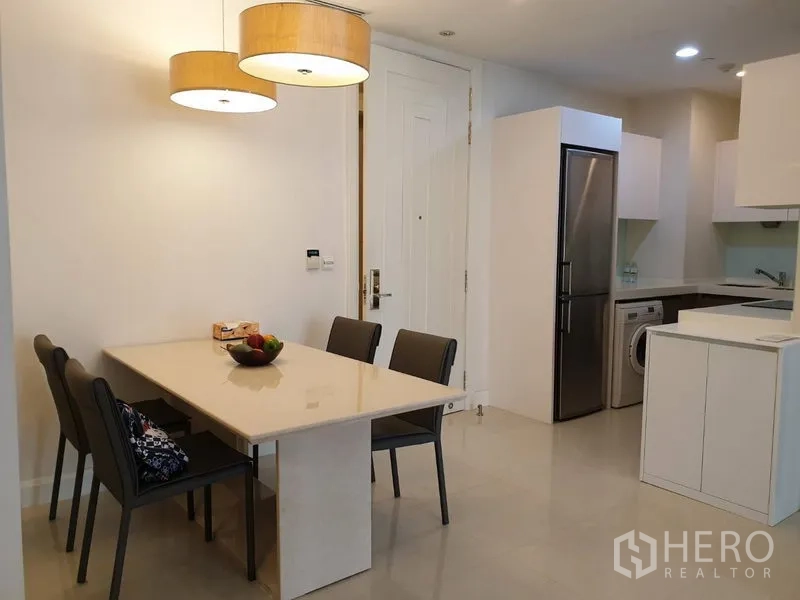 公寓 出租在Pathum Wan, Bangkok - 餐区设四人餐桌与吊灯，紧邻独立厨房。
