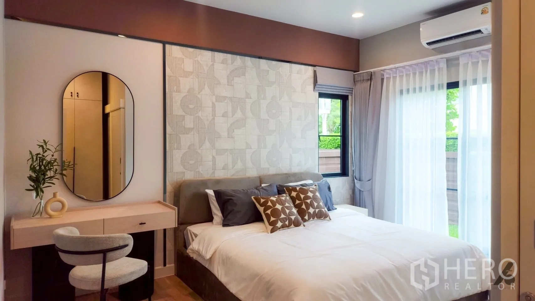 บ้าน ให้เช่าในBang Phli, Samut Prakan - ห้องนอนชั้นล่างอบอุ่น ผนังลายกราฟิก โต๊ะเครื่องแป้ง และหน้าต่างมองสวน