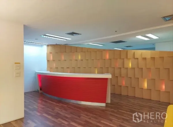 Office Space for rent in Chatuchak, Bangkok - Front desk area with a red counter set against a patterned wall in a contemporary office.