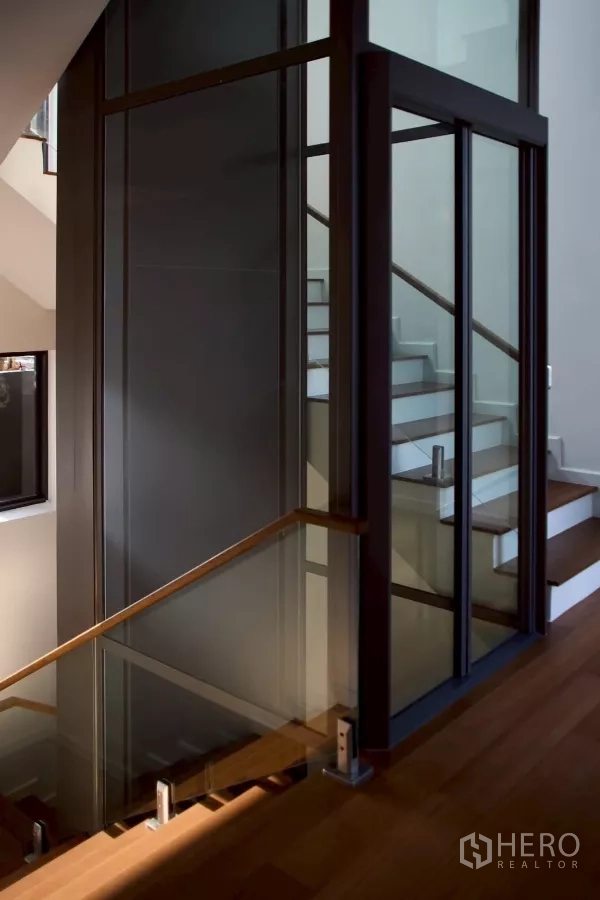 Detached House for sale in Lat Phrao, Bangkok - Private glass-door lift beside the timber staircase inside the house.