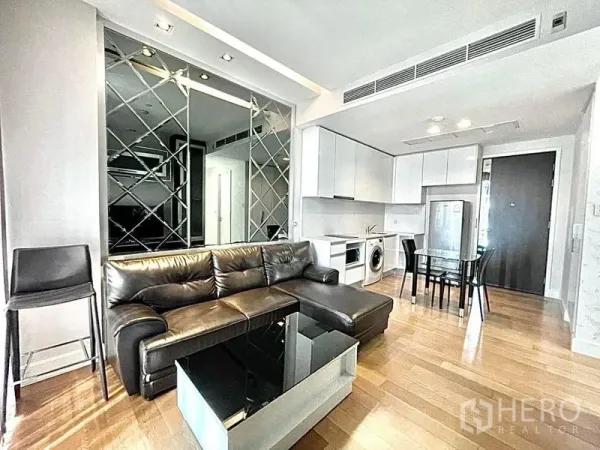 公寓 出租在Chatuchak, Bangkok - 开放客餐厅，皮沙发、镜面墙与全套厨房。