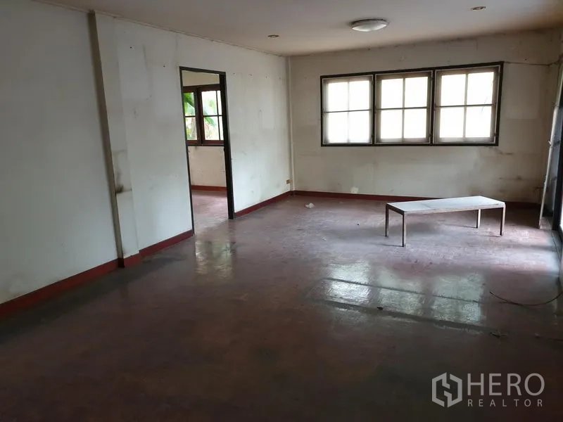 独立式住宅 出租或出售在Watthana, Bangkok - 宽敞客厅，多扇窗与浅色墙面，红色拼花地板。