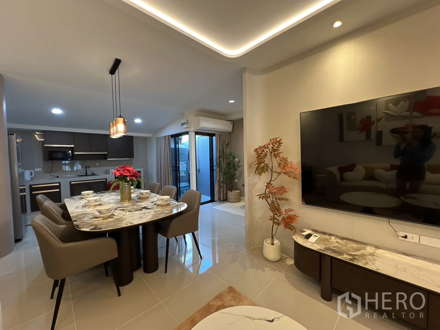 ทาวน์เฮาส์ for rent in Bang Phli, Samut Prakan - พื้นที่นั่งเล่น รับประทานอาหาร และครัวแบบโอเพนแปลน พร้อมโต๊ะหินอ่อนและทีวีจอใหญ่
