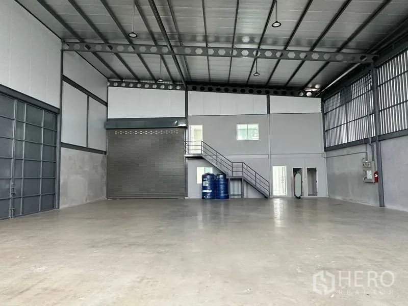 货栈 出租在Samut Prakan - 开阔库区，高屋顶、卷帘门、小窗与设备区