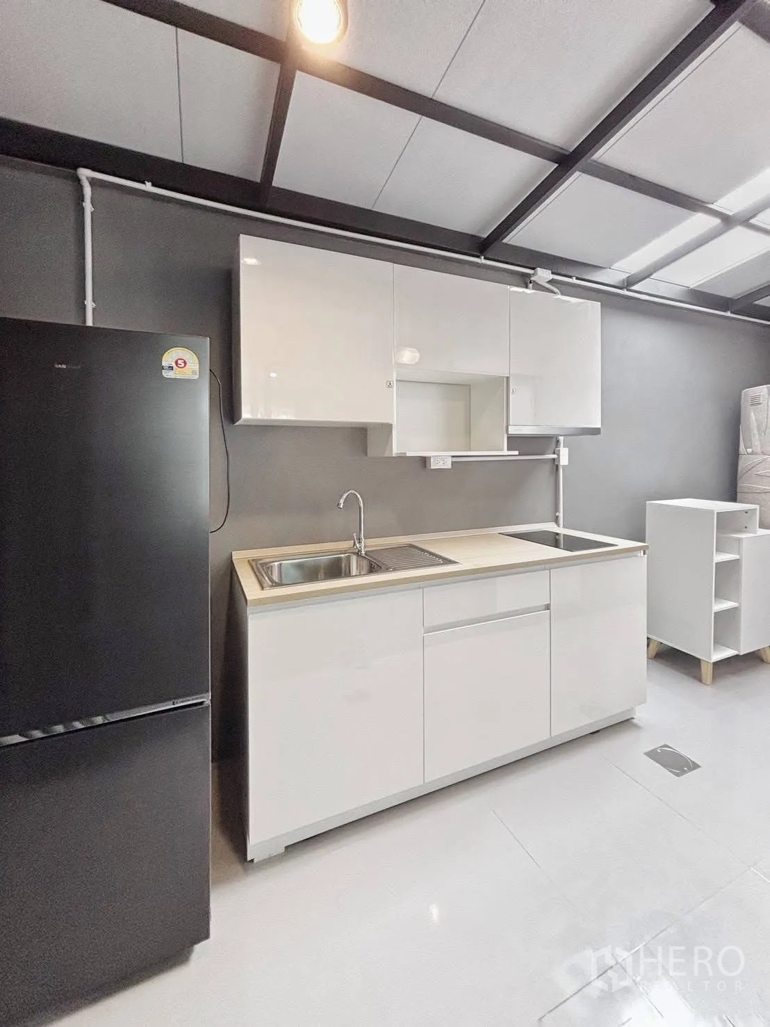 ทาวน์เฮาส์ for rent in Bang Phli, Samut Prakan - ครัวบิวท์อินตู้สีขาว ซิงก์ เตาไฟฟ้า ตู้เย็นสีดำ เพดานโครงเหล็ก